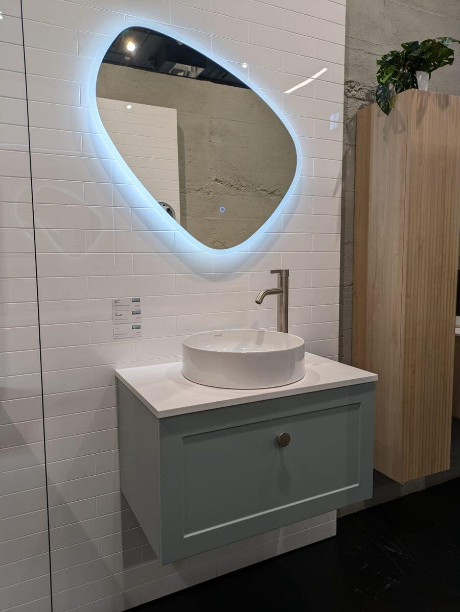 Sage green vanity with a round basin and organic LED mirror