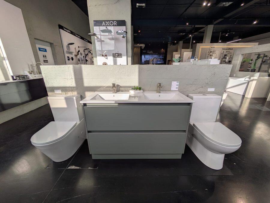 A double vanity on display between two toilet suites