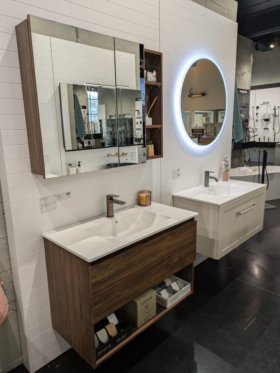 Walnut and white vanities with a mirrored cabinet above