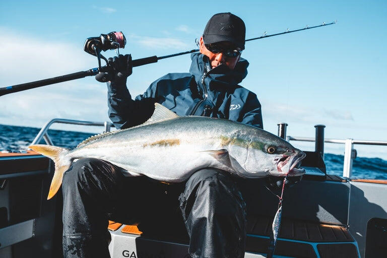 Daiwa Saltiga Image holding fish with Rod above head