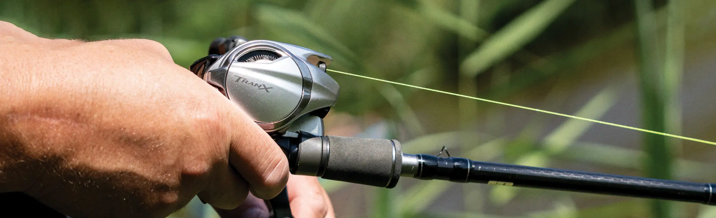 Shimano TRANX Feature Image - Person with Reel on Rod